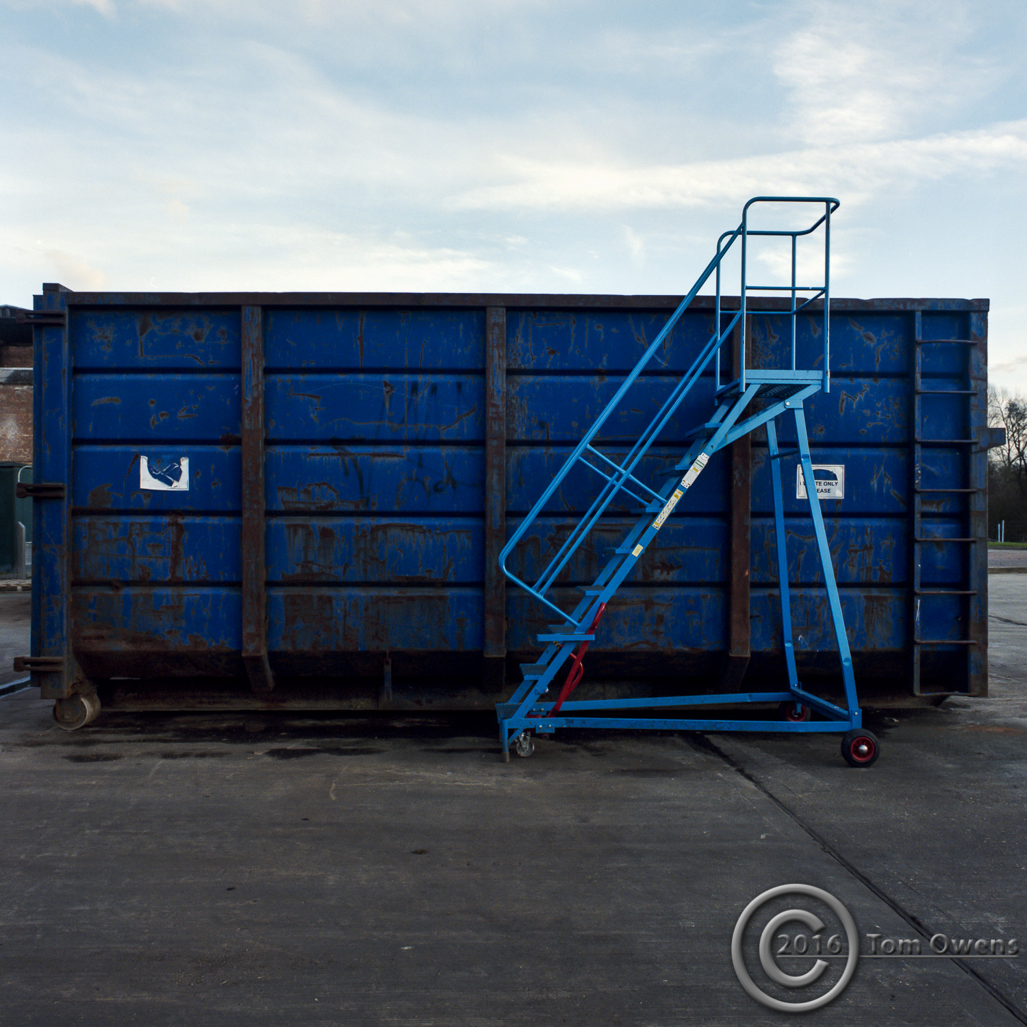 Blue commercial waste bin with cyan steps in front