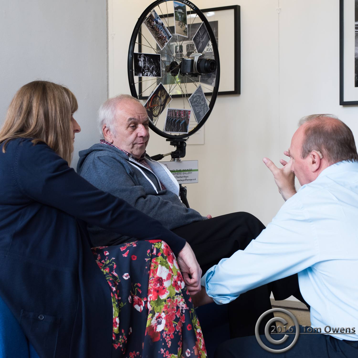 Man and woman on seat with man kneeling in front