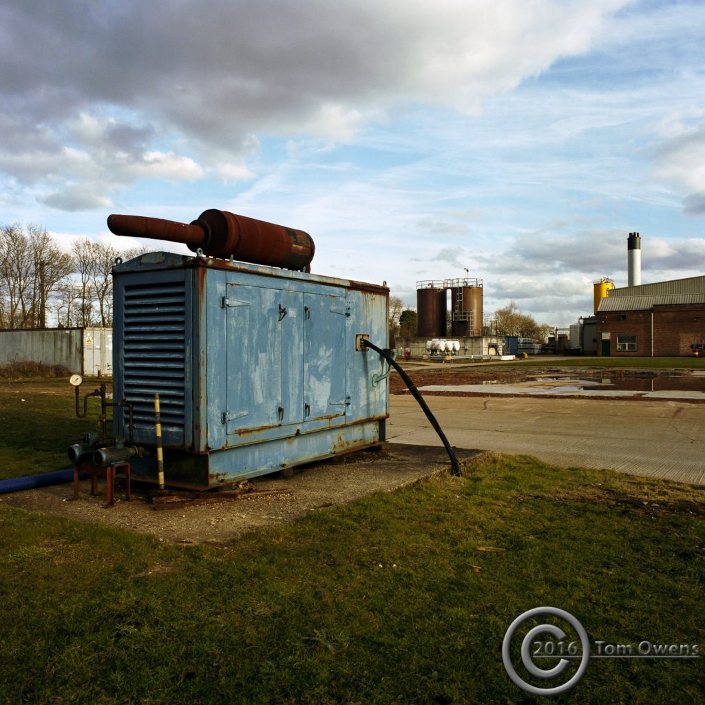 Faded blue emergency generator with rusty exhaust