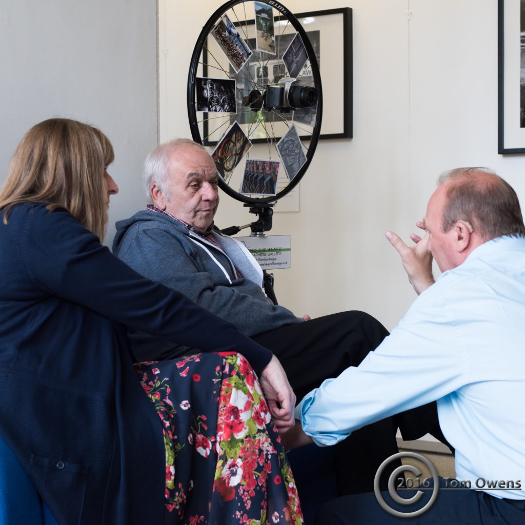 Man and woman on seat with man kneeling in front