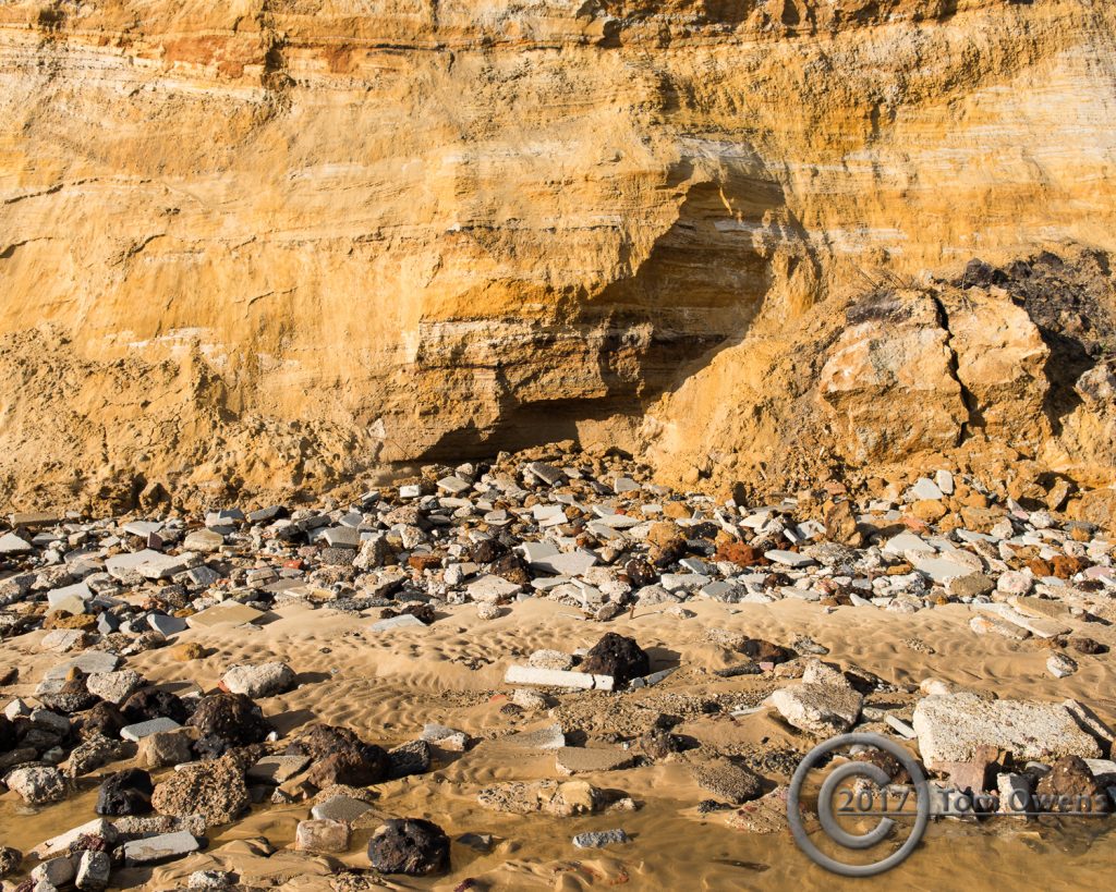 Yellow sandy cliff with rubble at the base