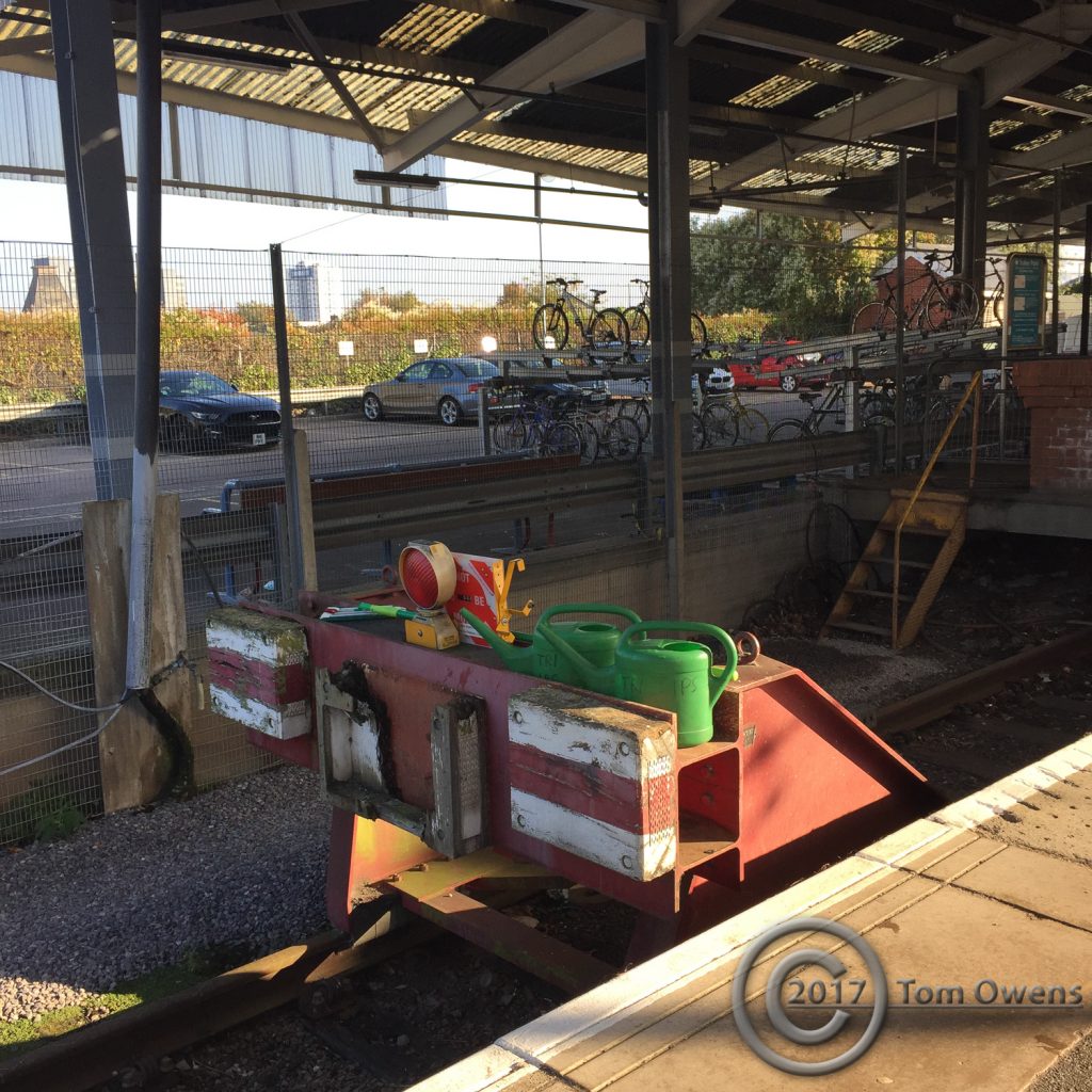 2 watering cans on railway buffers